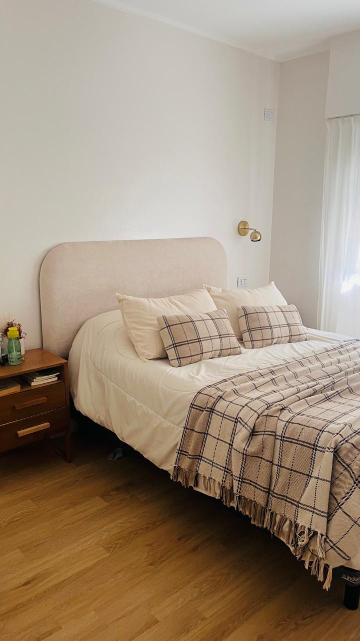Dormitorio con cama matrimonial y respaldo tapizado