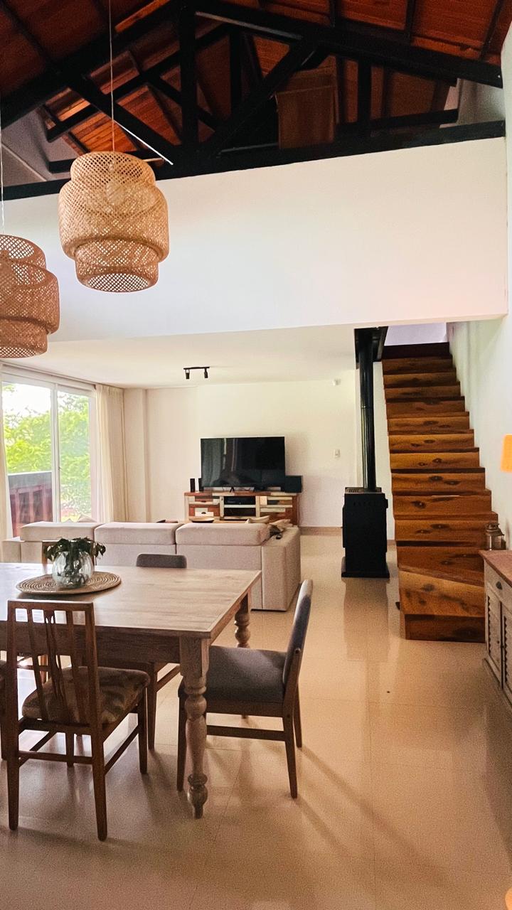 Living comedor de doble altura, con techo de madera y escalera