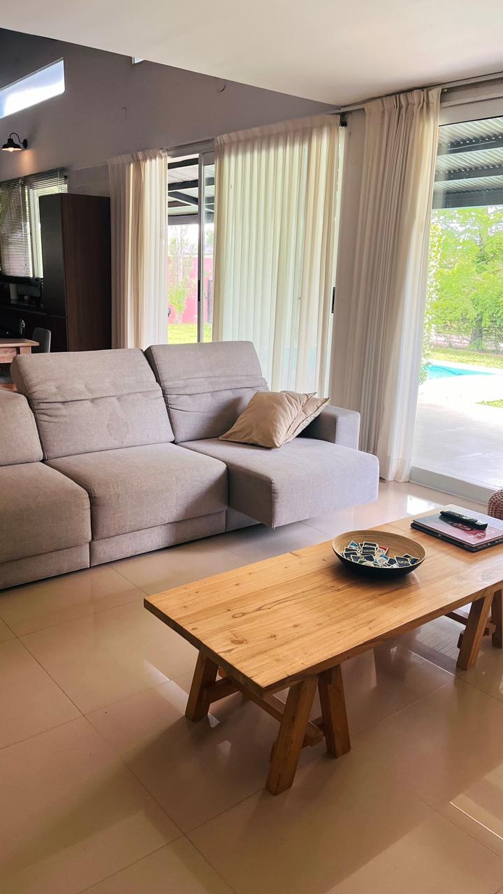 Living con sofá y grandes ventanales hacia el exterior