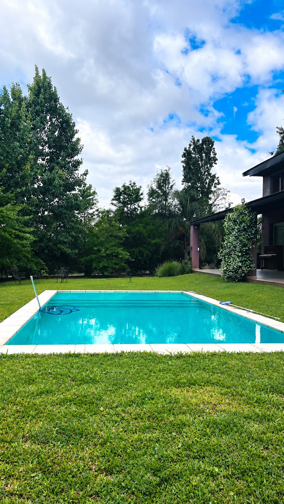 Pileta de la quinta, con parque y casa al fondo