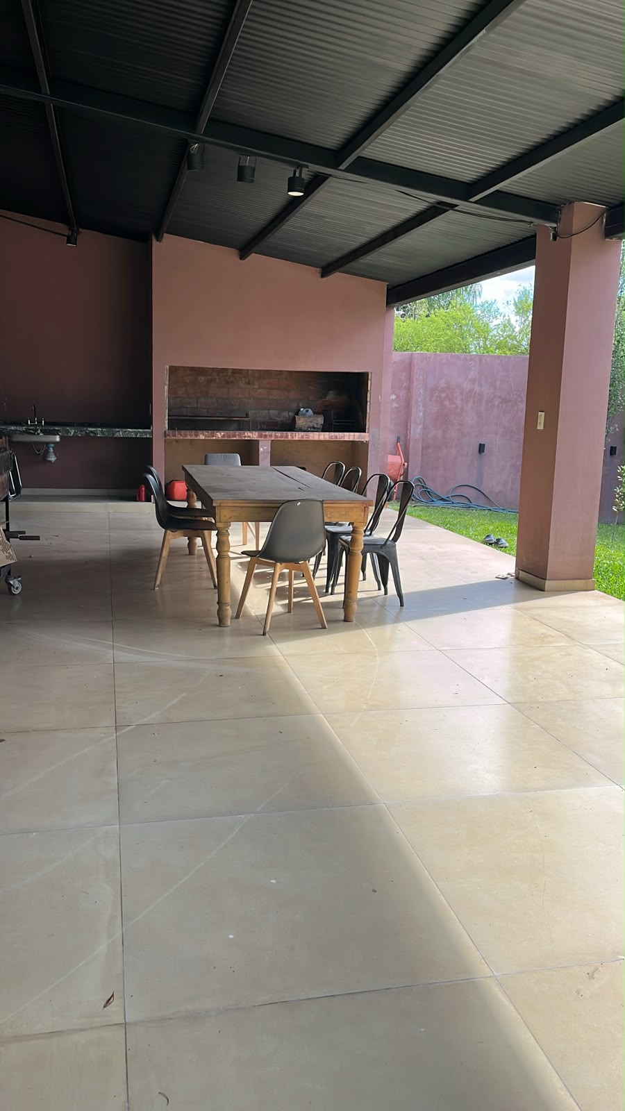 Galería techada con mesa, parrilla de obra y mesada con pileta